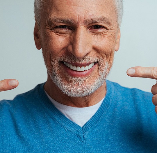 A man pointing to his new dentures