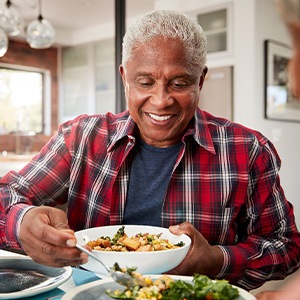 Senior man filling plate at table