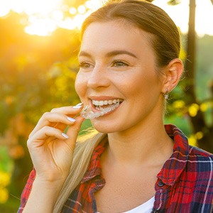 Woman outside inserting a clear aligner