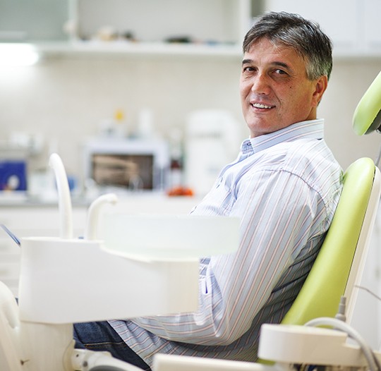 Patient smiling while sitting in treatment chair