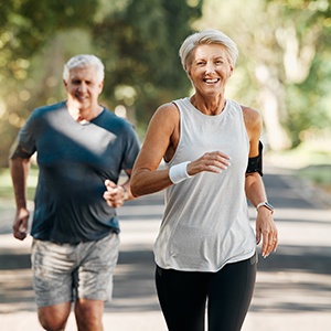 Couple smiling while jogging on trail outside